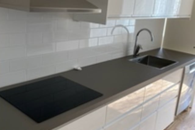 Köksrenovering i Stockholm bild på helt nytt kök med fläkt, skåp, spis och handfat